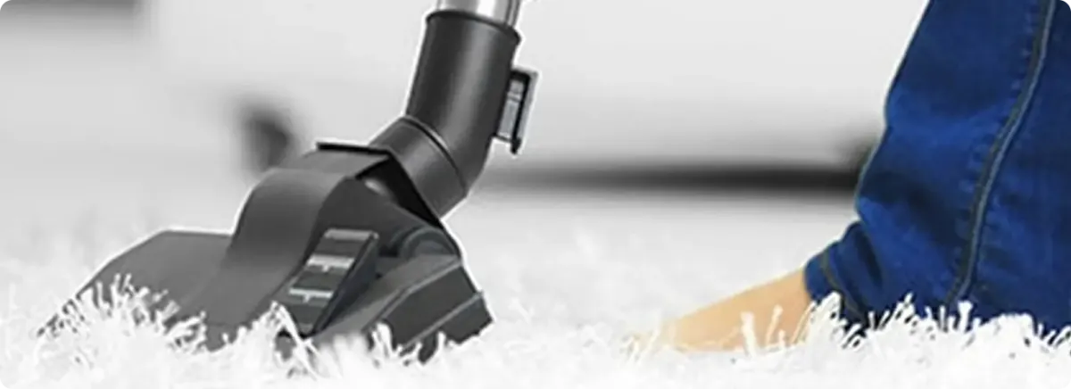 Close-up of a professional vacuuming a white carpet in Centerville.